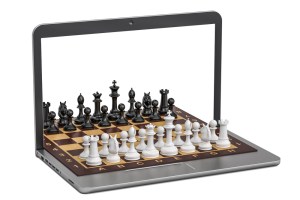 на изображении шахматная доска , расположенная на экране ноутбука