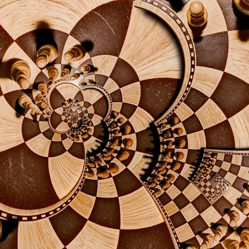 на изображении шахматные фигуры на шахматной доске, расположенной в форме круглых лепестков цветка