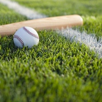 на изображении на зеленой траве (поле) лежит резиновый мяч и деревянная бита для игры в лапту.