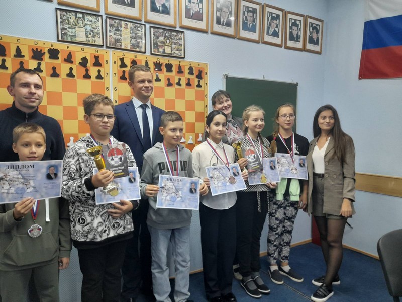  на фотографии награждение победителей и призеров соревнований по классическим шахматам, дети с дипломами, медалями и кубками в руках