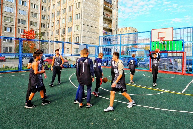 на фотографии подростки играют в баскетбол, на обновлённой спортивной площадке