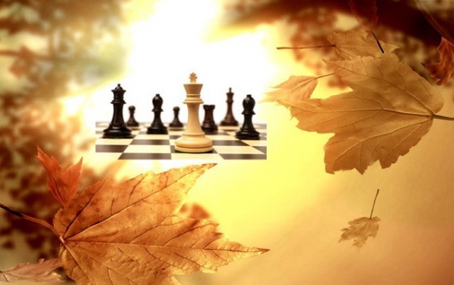 на фоне осенних листьев в центре изображено шахматное поле с фигурами