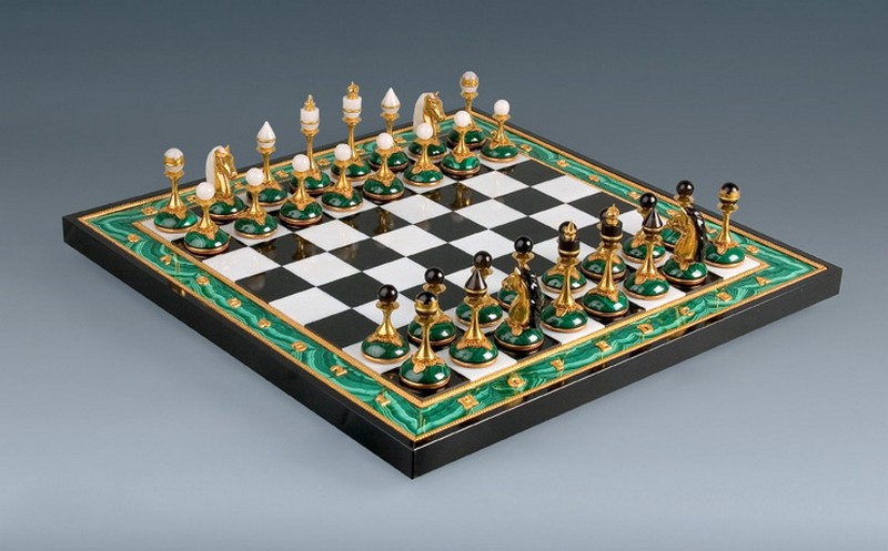 на изображении малахитовая шахматная доска с расставленными фигурами
